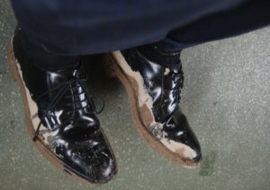 GROS PLAN SUR CHAUSSURES DE VILLE HOMME BOUEUSES PORTEES PAR UN HOMME D'AFFAIRES